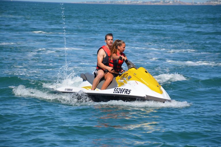 Two people riding one jet ski together on the Algarve sea
